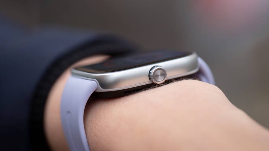 A close-up of a Redmi Watch 5 on a wrist, featuring a silver case and a light purple strap.