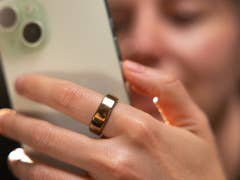 A person wearing the RingConn Generation 2 Smart Ring and holding an iPhone