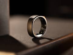 Close-up of a sleek black smart ring on a dark surface, showcasing its modern design.