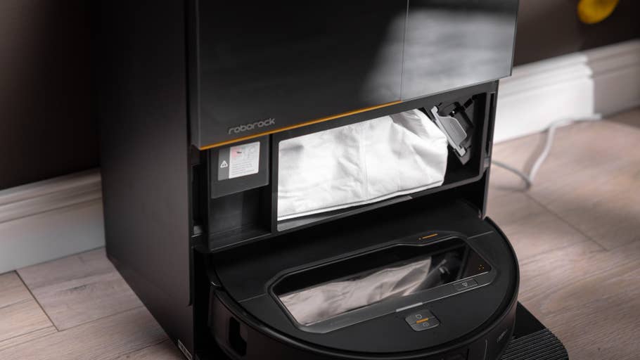 Roborock Saros Z70 robot vacuum cleaner with open dust container showing a dust bag.