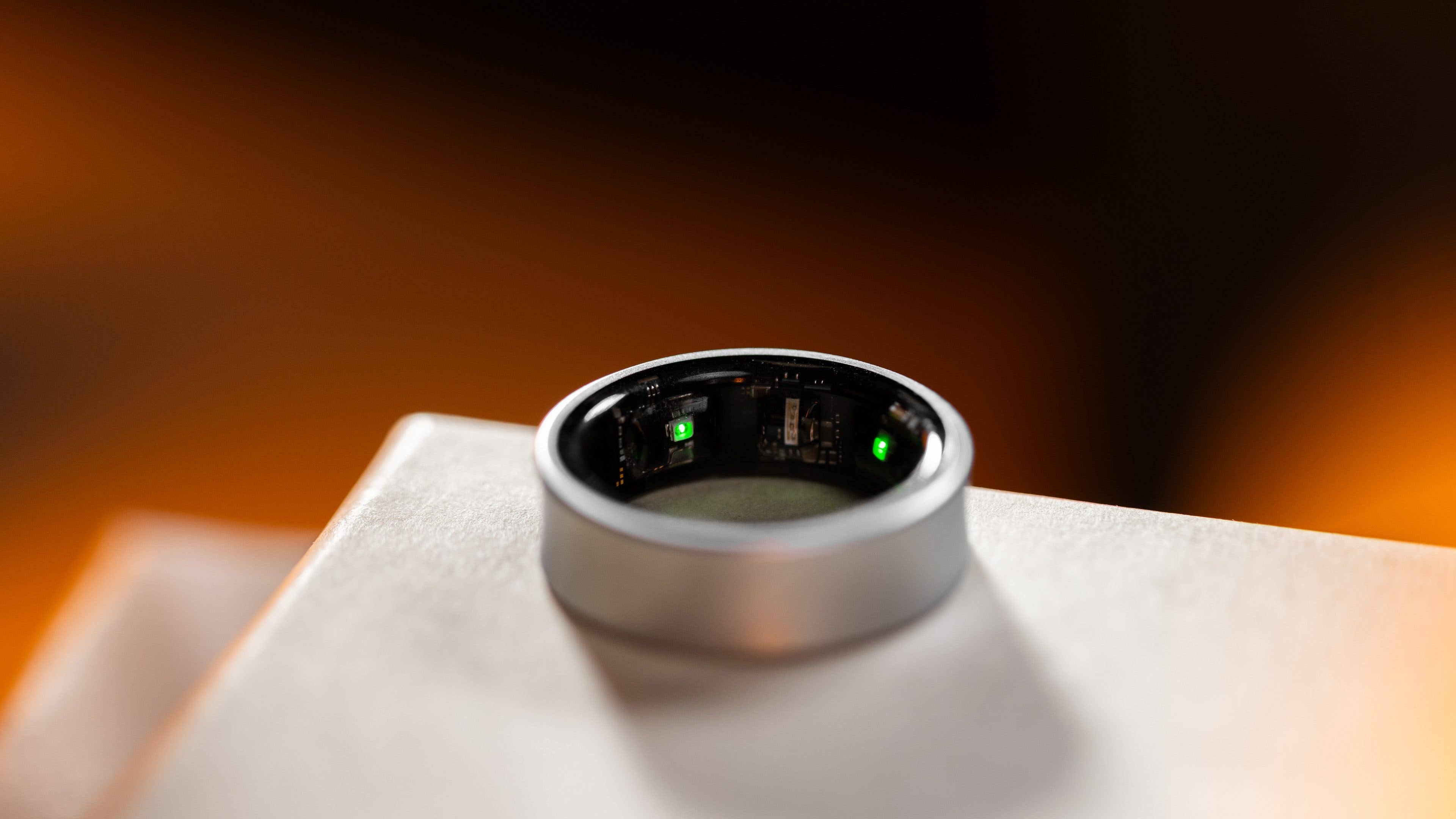 Close-up of a Samsung Galaxy Ring, showing its inner components and a green light. Close-up of a Samsung Galaxy Ring, showing its inner components and a green light.
