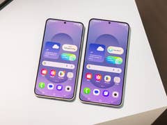 Two Samsung Galaxy S25 smartphones displaying a user interface with weather and app icons.