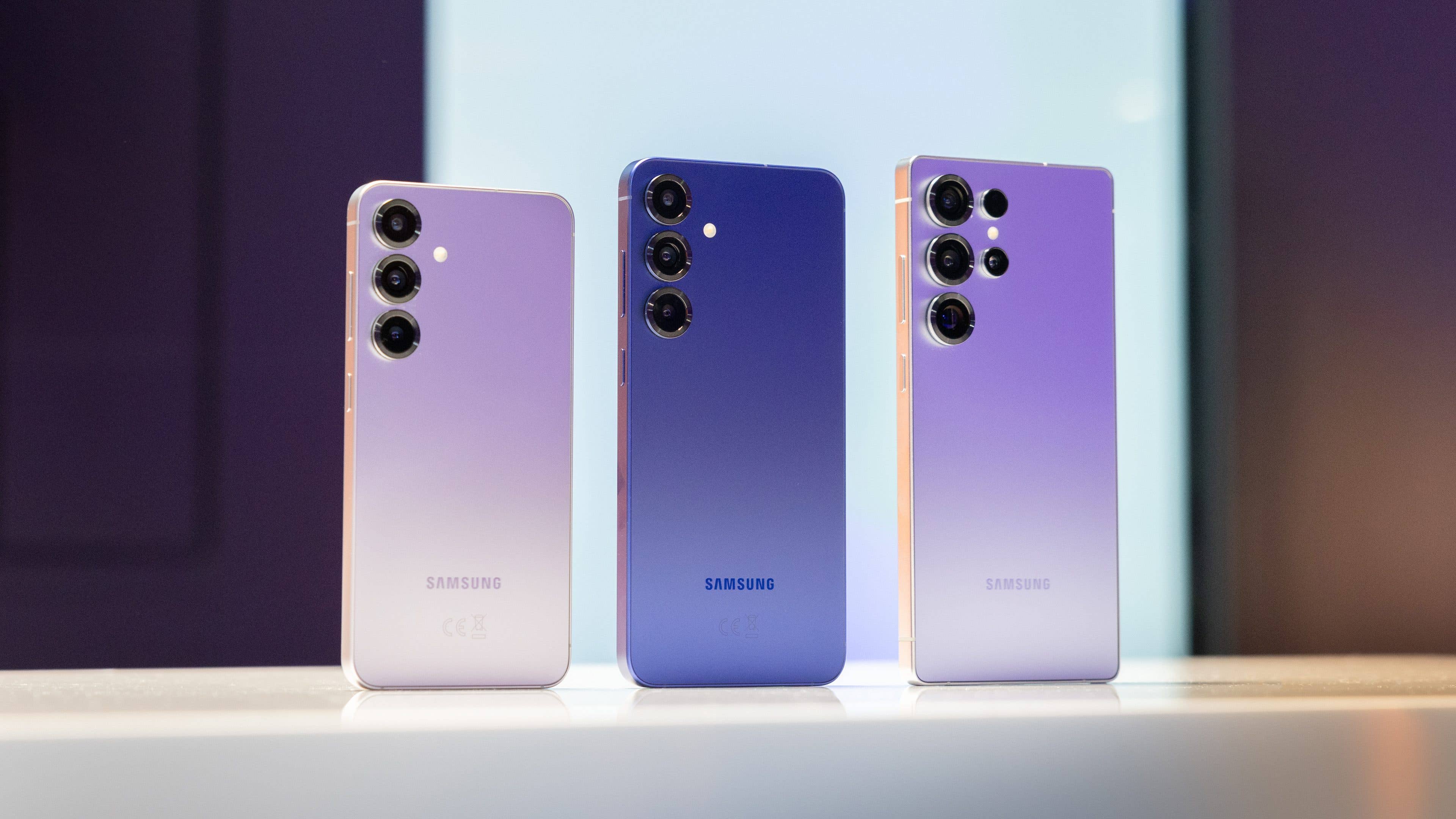 Three Samsung Galaxy S25 smartphones in gradient colors displayed on a table.