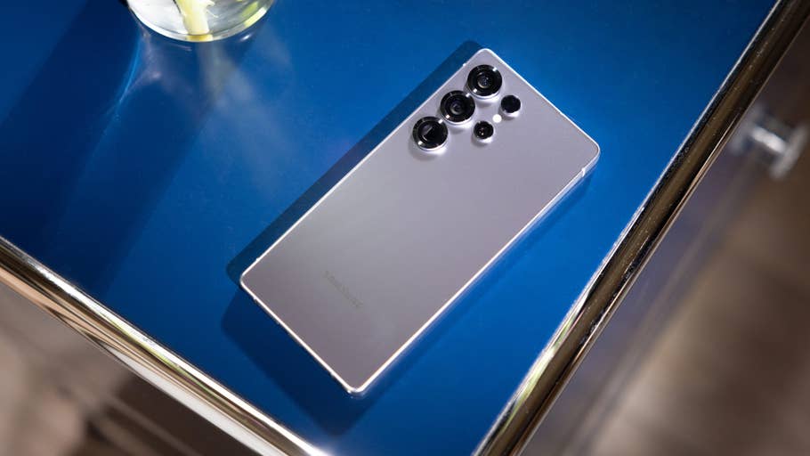 A Samsung Galaxy S25 Ultra smartphone on a blue table surface.