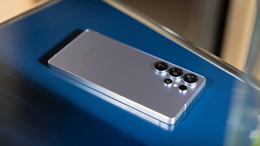 A Samsung Galaxy S25 Ultra smartphone lying on a blue surface.