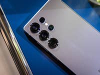 Samsung Galaxy S25 Ultra smartphone with multiple camera lenses on a blue surface.