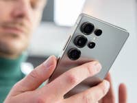 A person holding a Samsung Galaxy S25 smartphone, showcasing its multiple camera lenses.