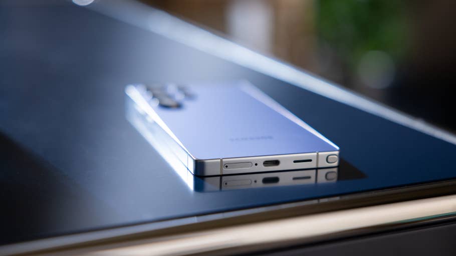 A Samsung Galaxy S25 Ultra smartphone resting on a reflective surface.