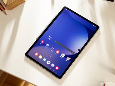 A Samsung Galaxy Tab S10+ displayed on a desk with various app icons on the screen.