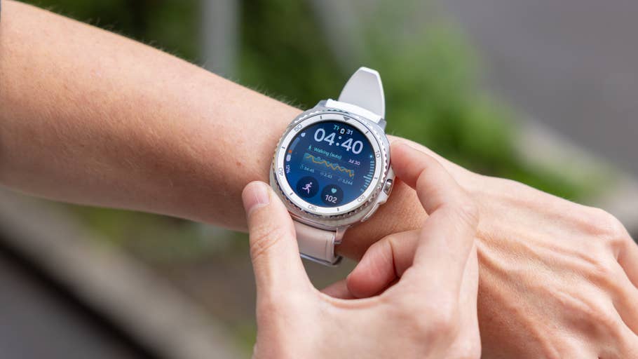 A person using a Samsung Galaxy Watch 8 Classic on their wrist, displaying time and fitness stats.