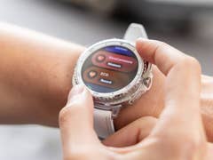A person interacting with a Samsung Galaxy Watch 8 Classic displaying health metrics.