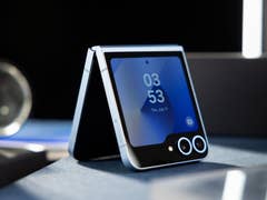 A half folded Samsung Galaxy Z Flip 6 in the standing position on a table
