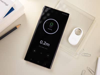 Samsung Galaxy SmartTag 2 viewed next to the Galaxy S23 Ultra smartphone