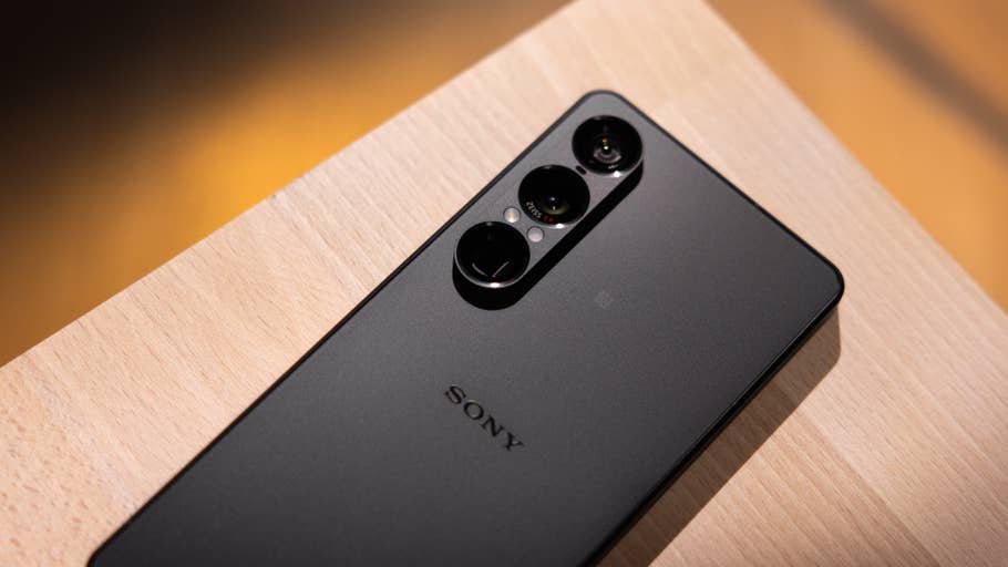 Close-up of the back of a Sony Xperia 1 VIII smartphone with three camera lenses on a wooden surface.