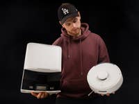 A person holding a robot vacuum clear