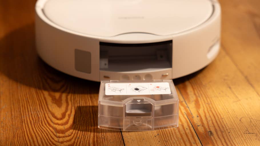 A SwitchBot S10 robot vacuum cleaner with an open dust container and instruction labels.