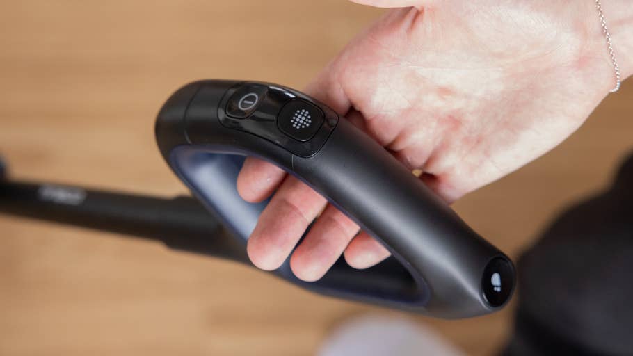 Close-up of a hand holding the handle of the Tineco Floor One S7 vacuum cleaner.