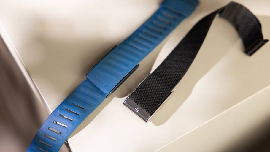 A blue WHOOP fitness strap and a black strap displayed on a surface.