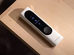 A Withings BeamO device displayed on a wooden surface, showing a temperature measurement screen.