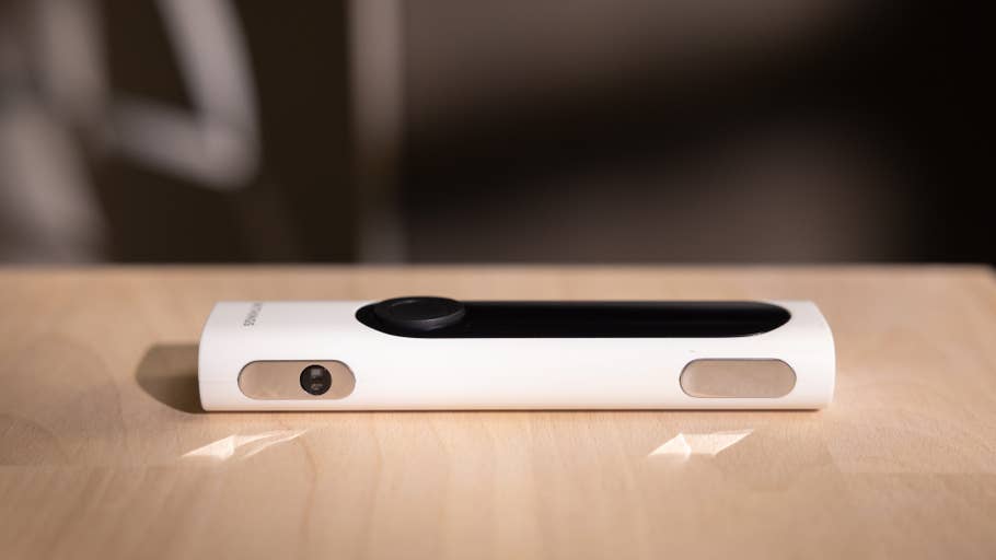 A Withings BeamO device is placed on a wooden surface, featuring a white exterior and a black sensor.