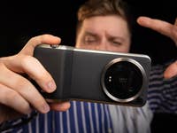 Xiaomi 14 Ultra seen from behind, held horizontally by a man standing in the background