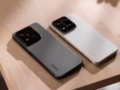 Two Xiaomi 15 smartphones, one gray and one white, resting on a wooden surface.