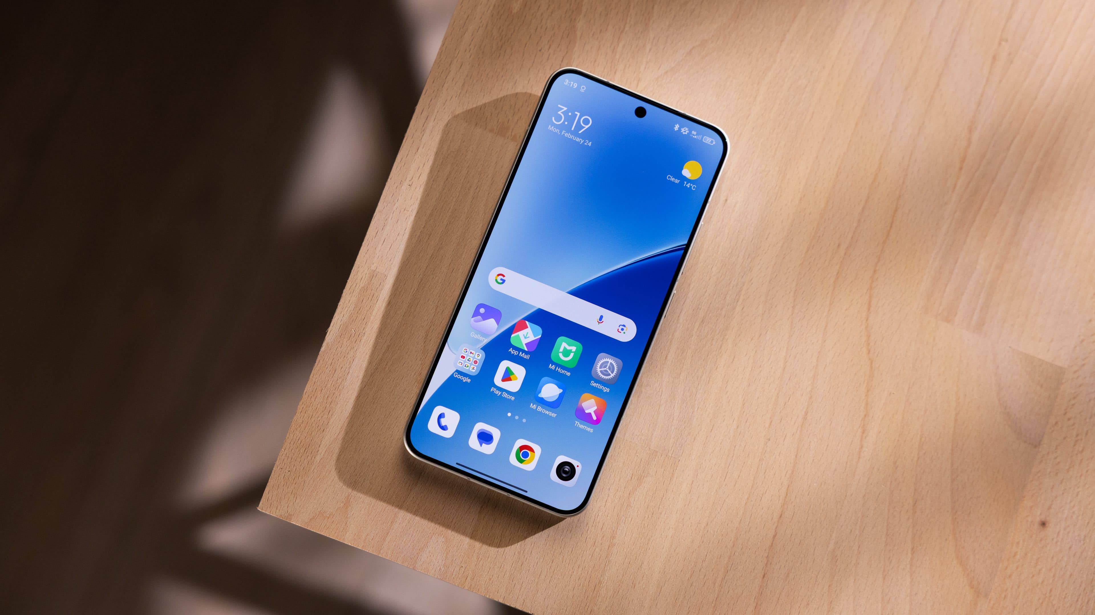 A Xiaomi 15 smartphone on a wooden surface, displaying a colorful app interface at 3:19 PM.