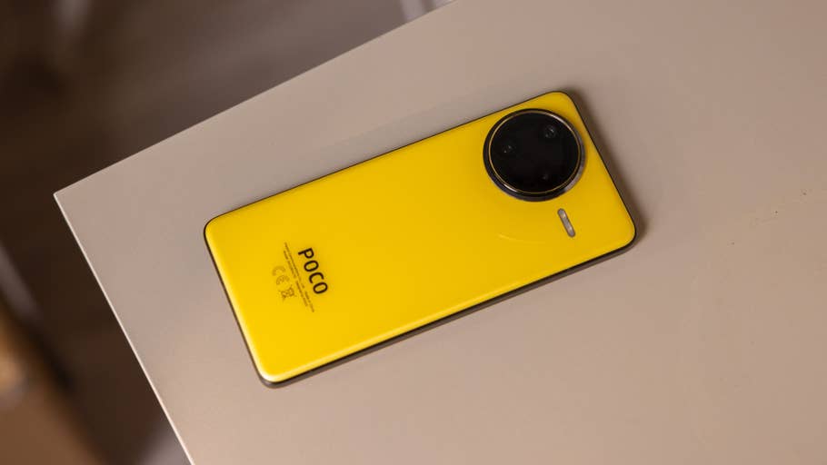 A yellow Poco F7 Ultra smartphone lies against a beige surface.