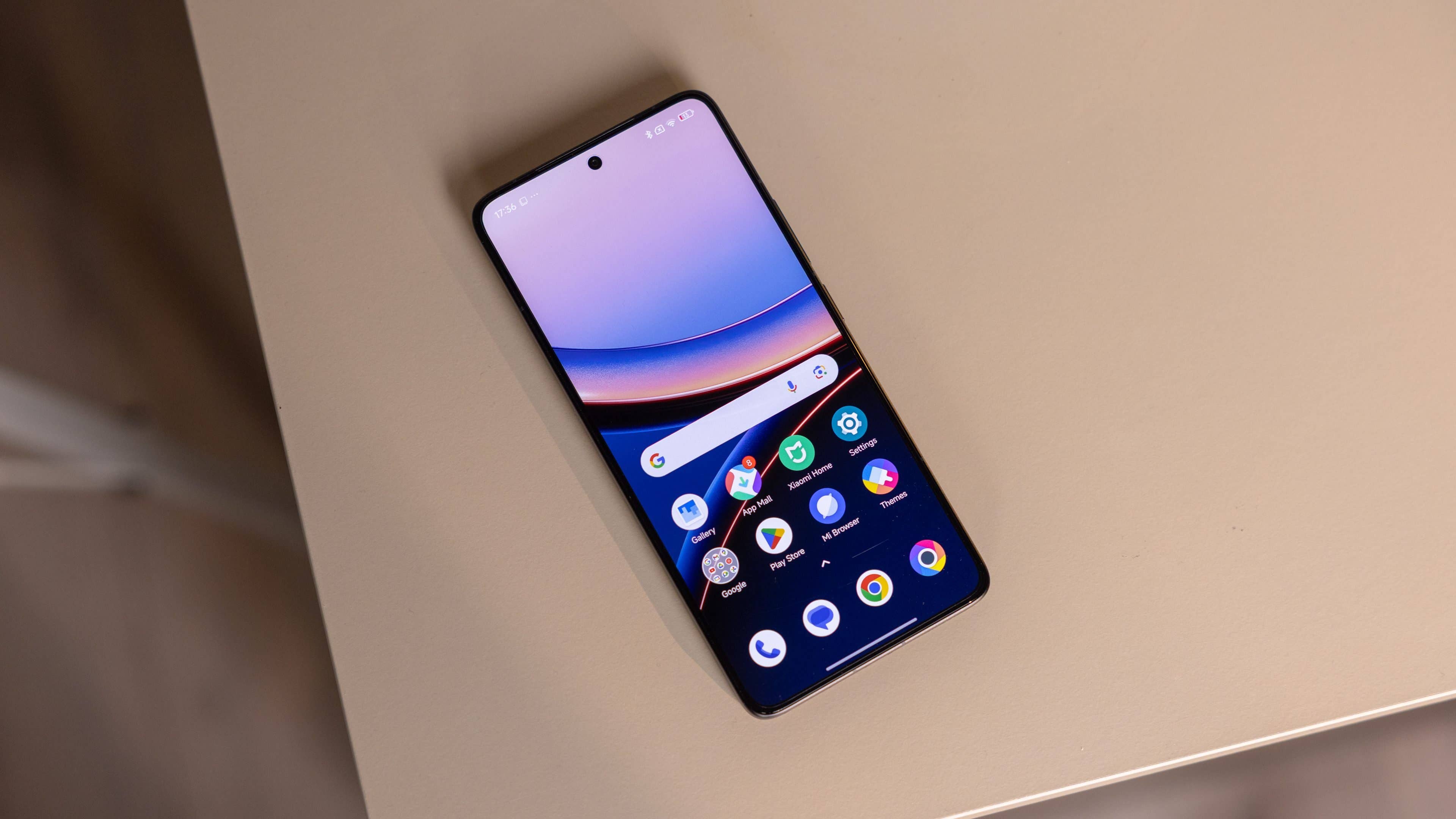 Un smartphone Poco F7 Ultra affiche un écran d'accueil coloré sur une surface beige.