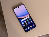 A Poco F7 Ultra smartphone displaying a colorful home screen on a beige surface.