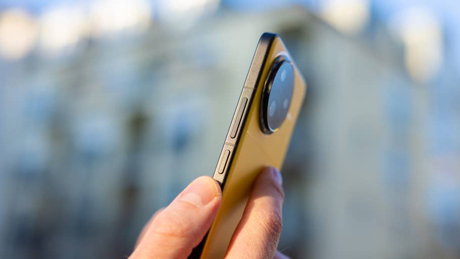 A person holds a Poco F7 Ultra smartphone showing its side buttons and camera module.