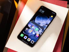 Xiaomi Mix Flip smartphone displayed on a white paper, showing the home screen with various app icons.