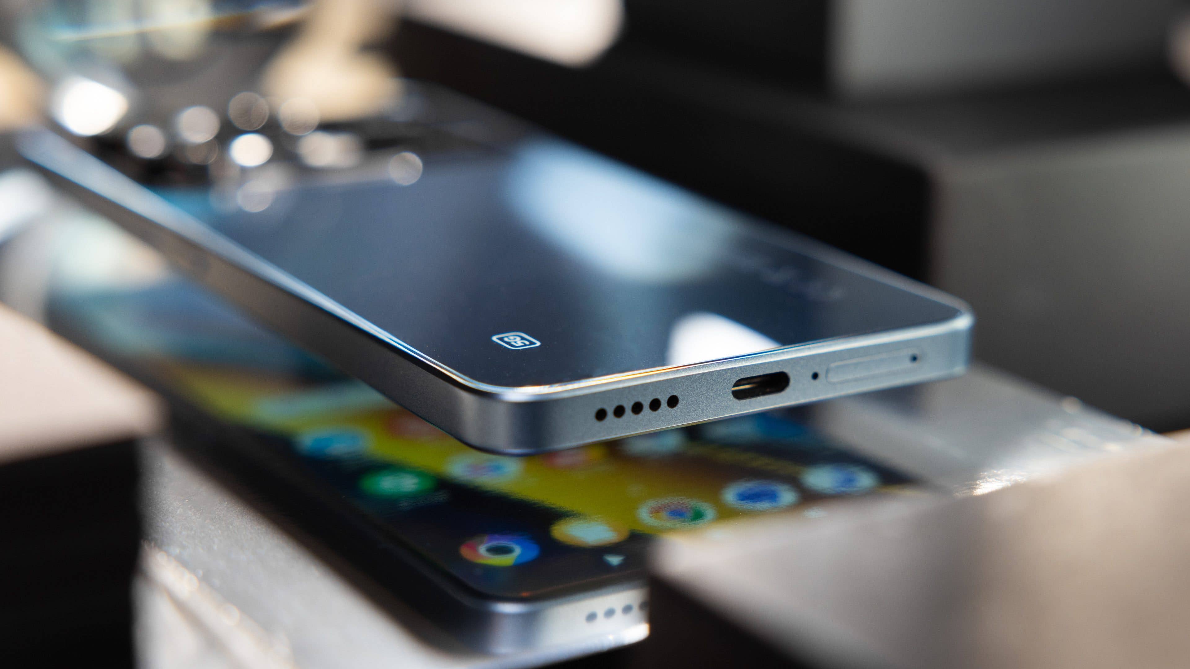 Bottom face of the Poco X6 showing the speaker grille, USB-C port, and dual SIM tray slot.