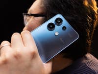 Xiaomi Redmi Note 13 4G held as a telephone next to the head