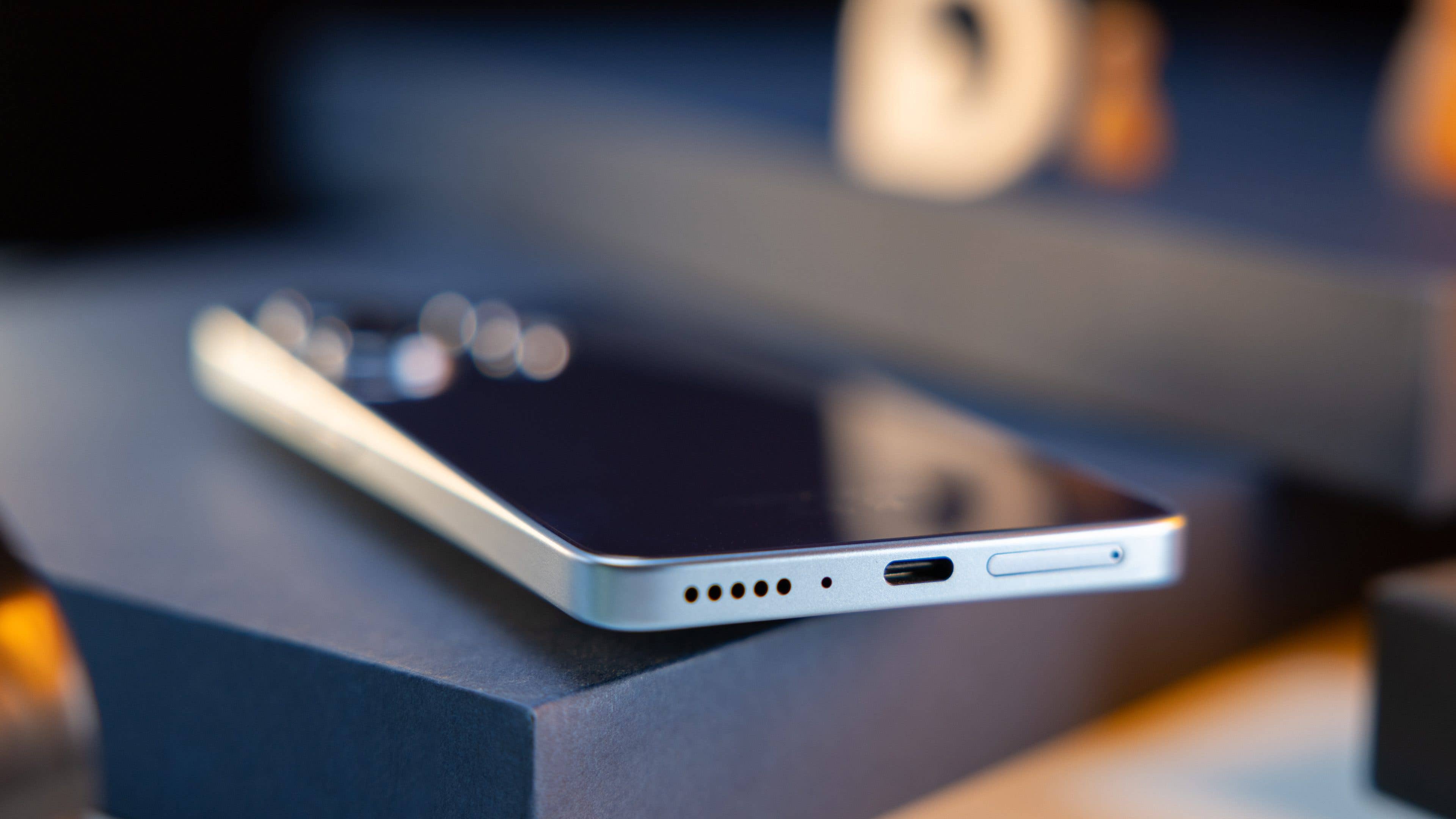 Bottom side of the Redmi Note 13 4G with the SIM card tray, a speaker grille, and USB-C charging port