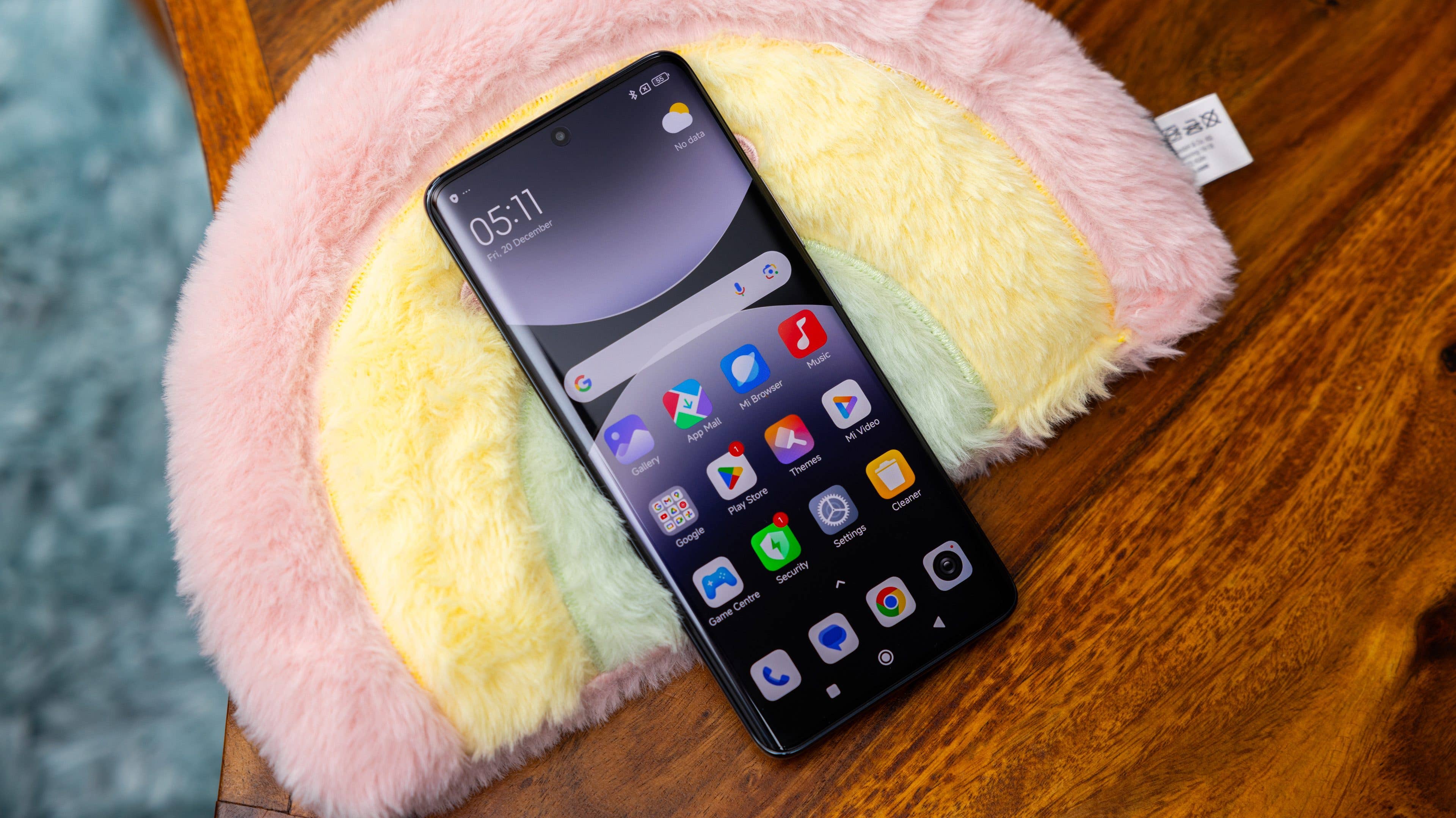 Xiaomi Redmi Note 14 Pro 5G smartphone on a colorful plush surface displaying app icons.