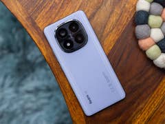 A Xiaomi Redmi Note 14 Pro Plus 5G smartphone in lavender color on a wooden table.