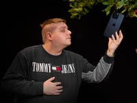 An iPhone 15 Pro Max hanging from a tree tempts the reviewer Antoine Engels