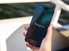 A person holding an iPhone 16 displaying the word 'bonjour' on the screen.