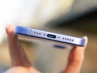 Close-up of an iPhone 16 showing the bottom with a USB-C port and speaker holes.
