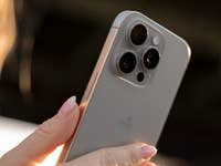 A person holds an iPhone 16 Pro and shows off the triple camera design.