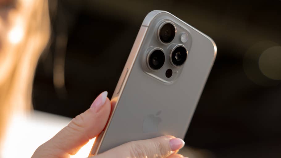 A person holds an iPhone 16 Pro and shows off the triple camera design.