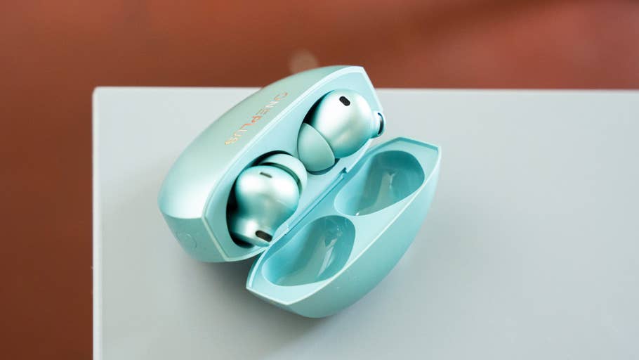 An open charging case with two OnePlus Buds 4 inside.