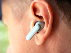 Close-up of a OnePlus Buds 4 wireless earbud in an ear.