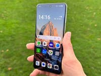 A person holding the Oppo Find X8 Pro smartphone outdoors with a mountain wallpaper displayed.