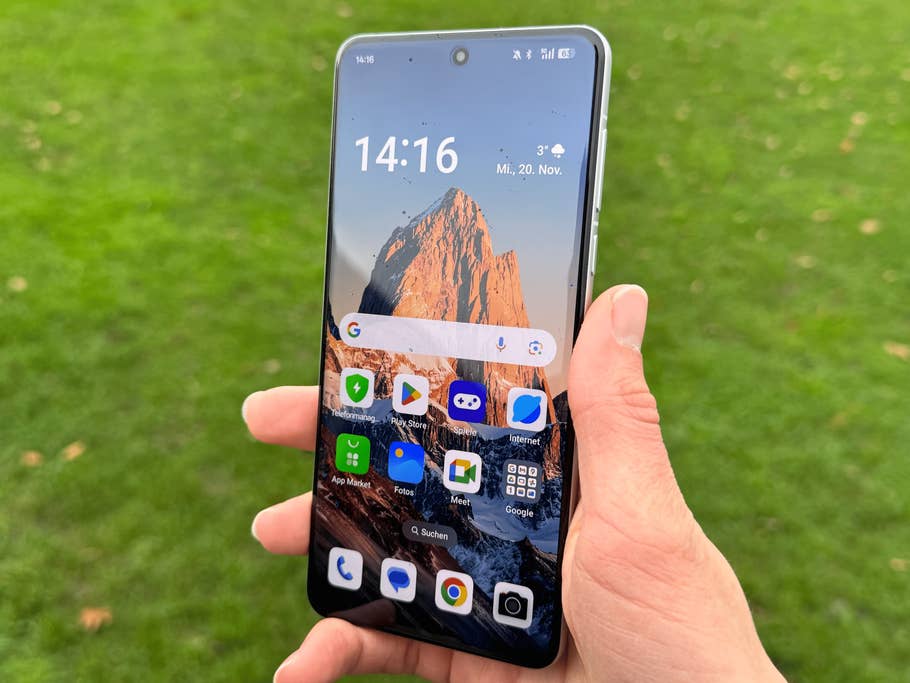 A person holding an Oppo Find X8 Pro smartphone which shows a mountain landscape on the screen.