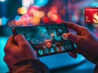 A person holding a smartphone displaying a vibrant gaming scene with a Snapdragon 8 Elite logo.
