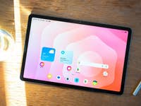 Samsung Galaxy Tab S11 on a wooden table with a water bottle and stylus next to it.