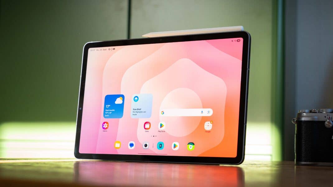 Samsung Galaxy Tab S11 displaying a colorful app interface on a wooden table.