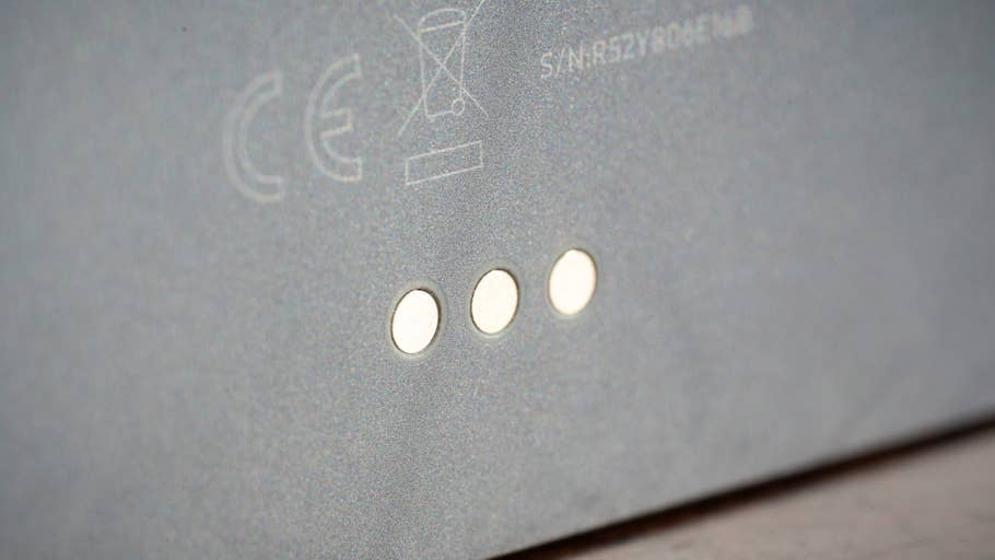 Close-up of the Samsung Galaxy Tab S11 showing three contact pins on a gray surface.